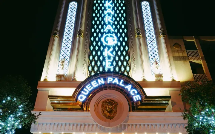 다낭 퀸 팰리스 가라오케 QUEEN PALACE 간판이 있는 건물 외관 야경