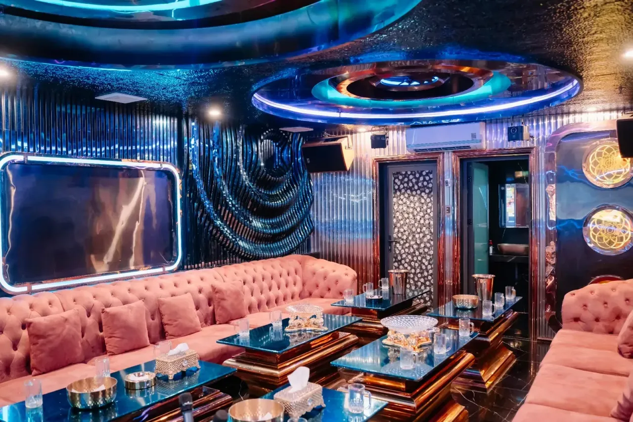 다낭 X8 클럽 노래방 (S18) 분홍 소파와 유리 테이블, 원형 조명 천장의 단체 룸
