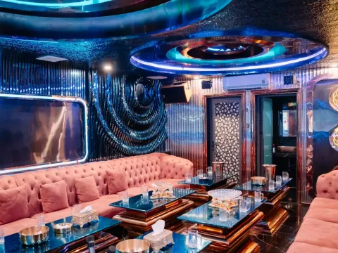 다낭 X8 클럽 노래방 (S18) 분홍 소파와 유리 테이블, 원형 조명 천장의 단체 룸